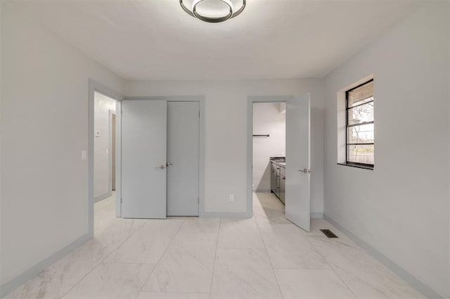 bedroom featuring visible vents, marble finish floor, connected bathroom, and baseboards