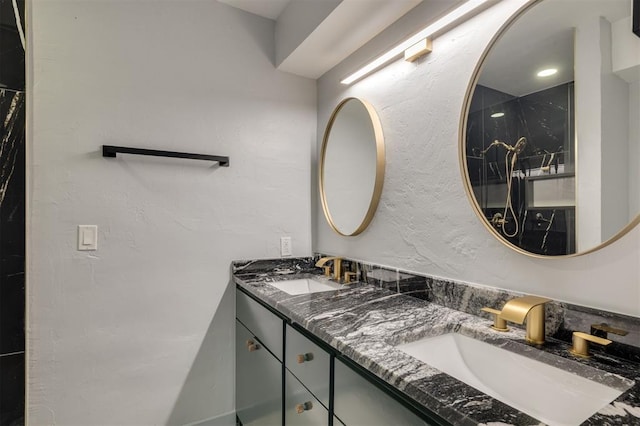 bathroom featuring a sink, double vanity, and a textured wall