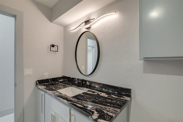 bathroom with vanity and a textured wall