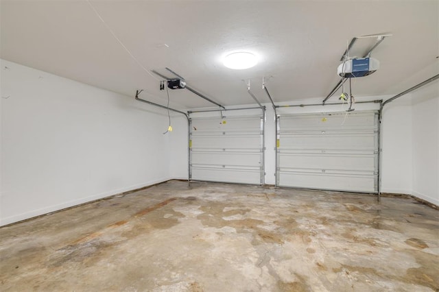 garage featuring a garage door opener and baseboards