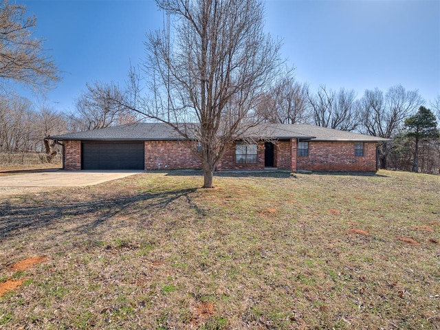 ranch-style home featuring concrete driveway, brick siding, a garage, and a front yard