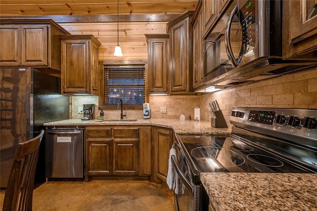kitchen featuring backsplash, decorative light fixtures, light stone counters, stainless steel appliances, and a sink