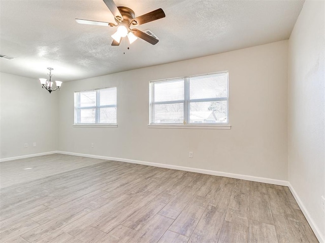 spare room featuring baseboards, a textured ceiling, and light wood-style flooring