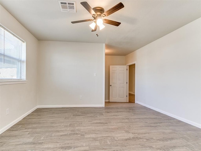 empty room featuring visible vents, baseboards, light wood-style floors, and a ceiling fan