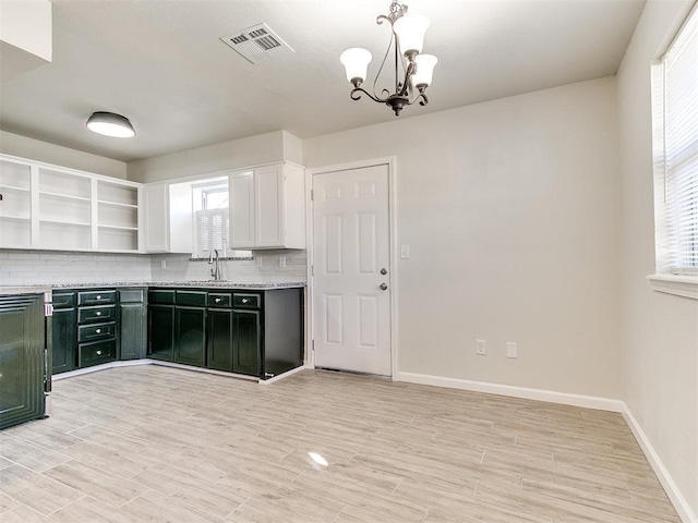 kitchen with visible vents, a sink, open shelves, tasteful backsplash, and light countertops