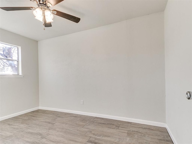 empty room with ceiling fan, light wood-style floors, and baseboards