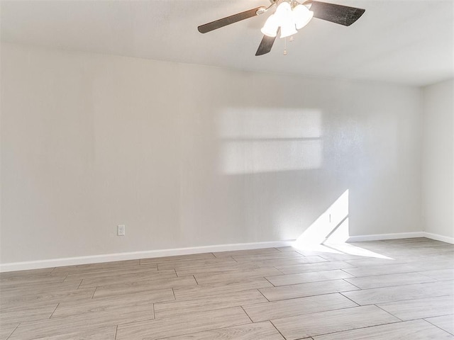 unfurnished room with ceiling fan, baseboards, and wood tiled floor