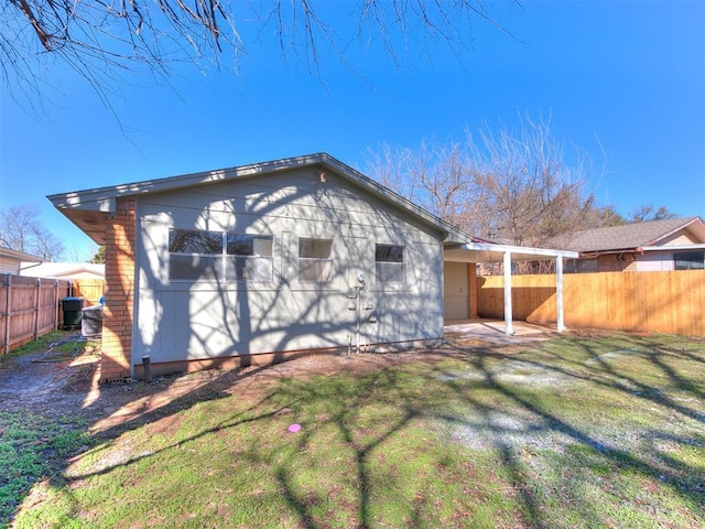 back of property featuring a yard, cooling unit, a fenced backyard, and a patio area