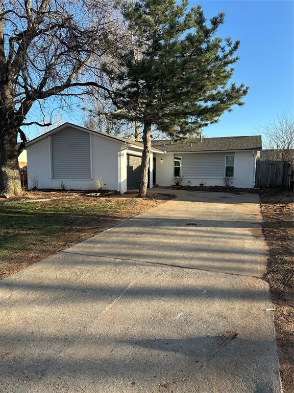 exterior space featuring an attached garage, fence, and driveway