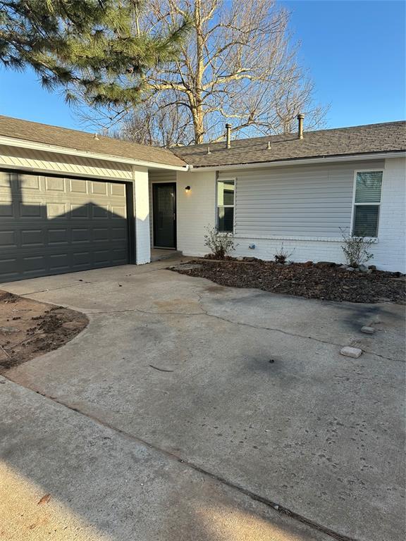 ranch-style home with brick siding, concrete driveway, and a garage