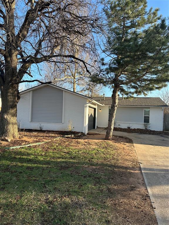 view of front of property with an attached garage, concrete driveway, and a front yard