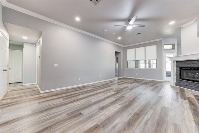 unfurnished living room with light wood finished floors, a fireplace, baseboards, and ornamental molding