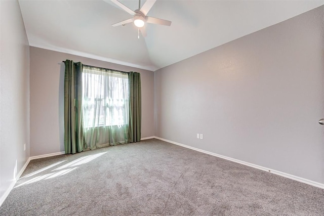 spare room with vaulted ceiling, carpet flooring, baseboards, and ceiling fan