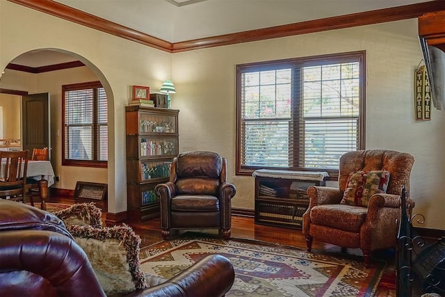 interior space with baseboards, wood finished floors, arched walkways, and ornamental molding