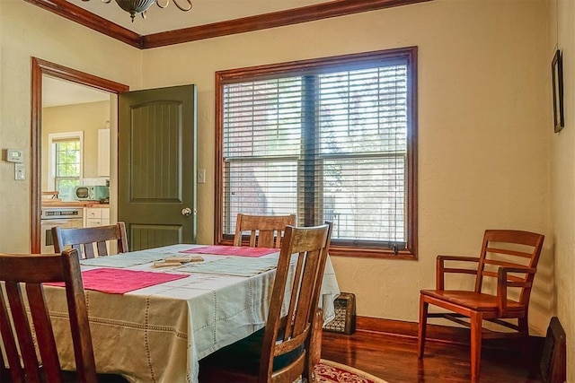 dining area with wood finished floors and ornamental molding