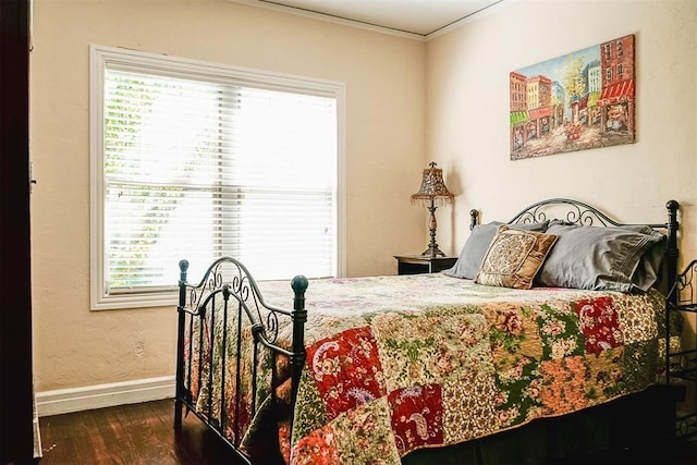 bedroom with baseboards, wood finished floors, and ornamental molding