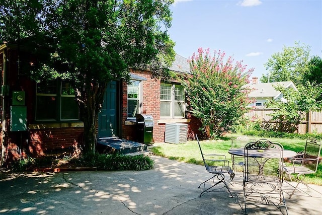 view of patio featuring a grill, outdoor dining area, and fence