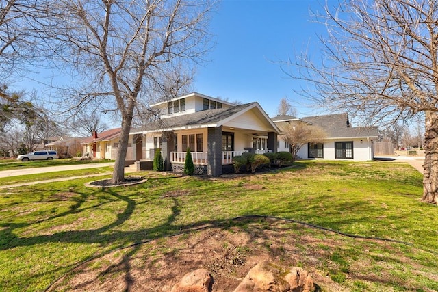 view of front of property featuring brick siding, covered porch, and a front yard