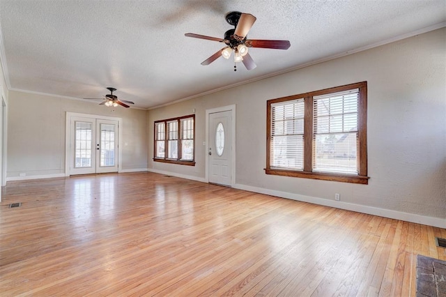 unfurnished living room featuring crown molding, visible vents, light wood-type flooring, and a textured ceiling