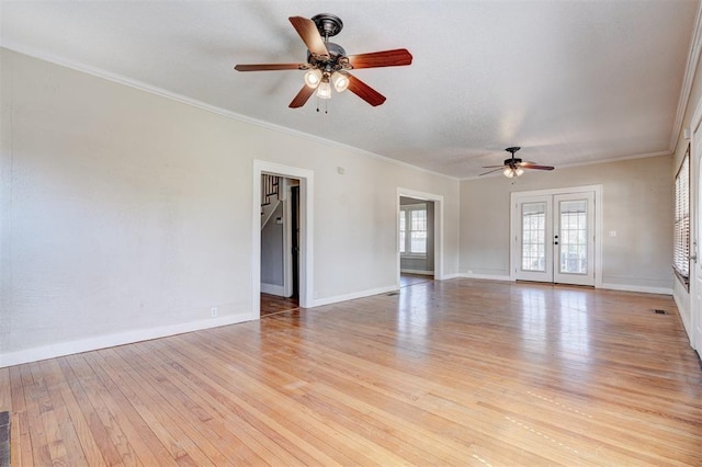 spare room featuring crown molding, light wood-style flooring, and baseboards