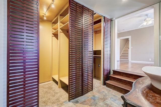 walk in closet with stone finish flooring and a ceiling fan