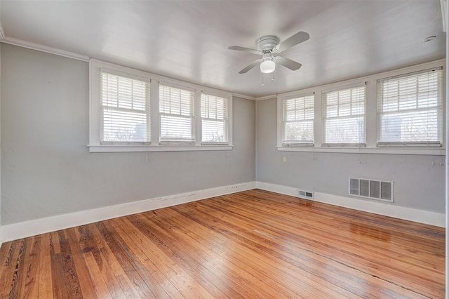 unfurnished room with light wood finished floors, visible vents, and baseboards