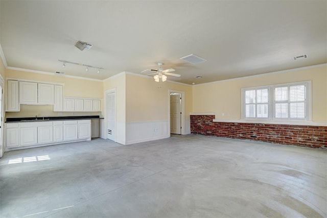 unfurnished living room with a sink, visible vents, concrete floors, and ornamental molding