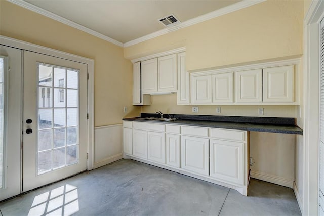 kitchen featuring visible vents, ornamental molding, a sink, concrete flooring, and dark countertops