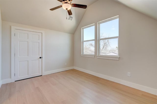 additional living space featuring visible vents, lofted ceiling, a ceiling fan, wood finished floors, and baseboards