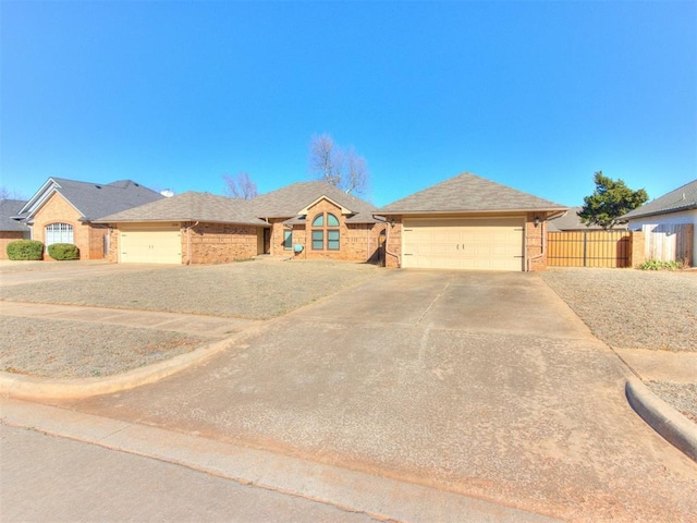 ranch-style house featuring driveway, fence, a shingled roof, a garage, and brick siding