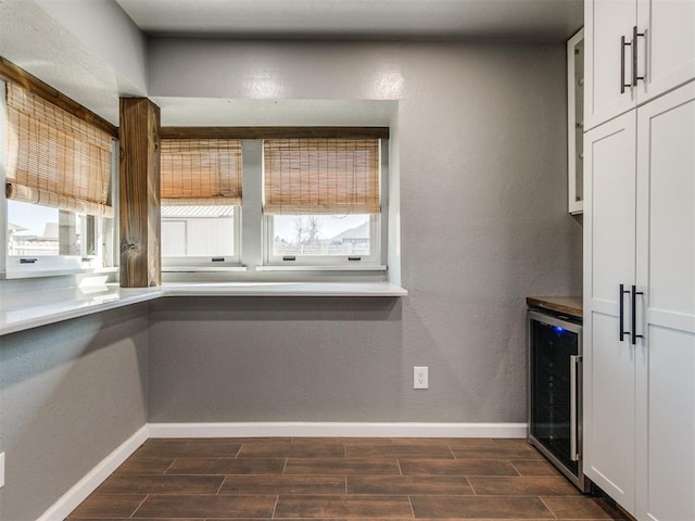 kitchen featuring beverage cooler, wood finish floors, and a wealth of natural light