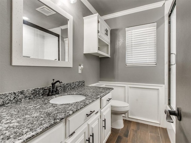 bathroom with toilet, wood tiled floor, ornamental molding, wainscoting, and vanity