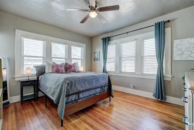 bedroom with ceiling fan, baseboards, and wood finished floors