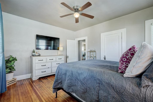 bedroom with baseboards, wood-type flooring, and ceiling fan