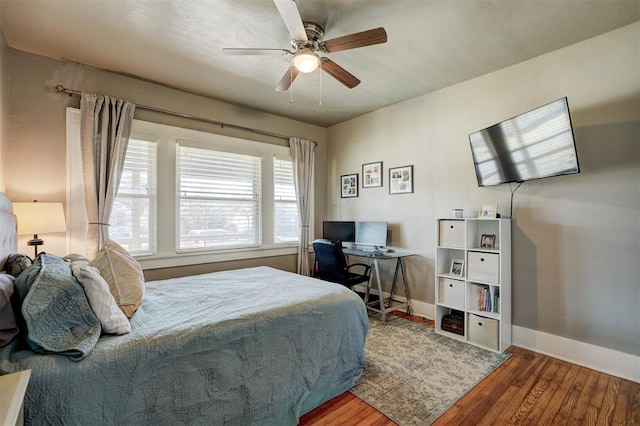 bedroom with ceiling fan, baseboards, and wood finished floors