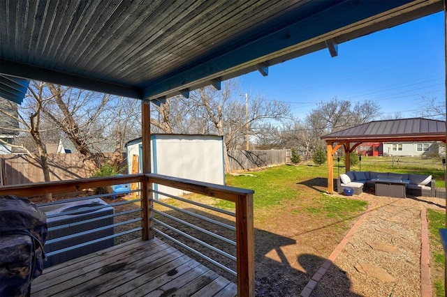 wooden deck with an outdoor hangout area, a storage shed, a fenced backyard, an outdoor structure, and a yard