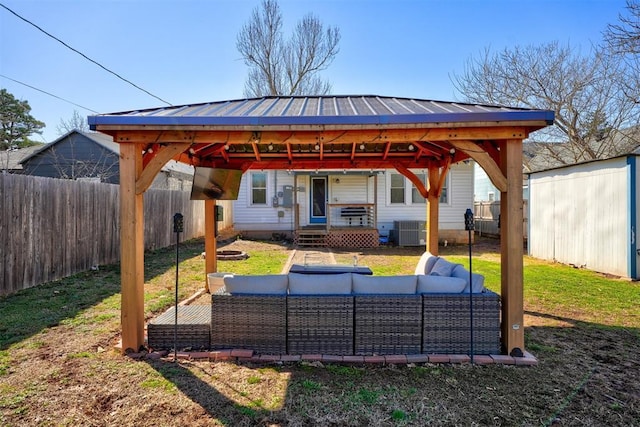 view of patio / terrace featuring an outbuilding, central AC unit, an outdoor hangout area, and a fenced backyard