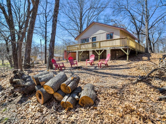 back of house with a deck and an outdoor fire pit