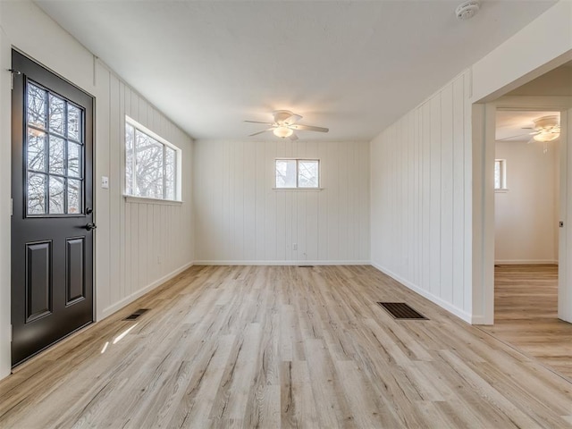 entrance foyer featuring visible vents, a healthy amount of sunlight, wood finished floors, and a ceiling fan