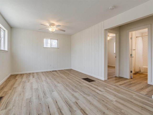 empty room with visible vents, baseboards, ceiling fan, and wood finished floors