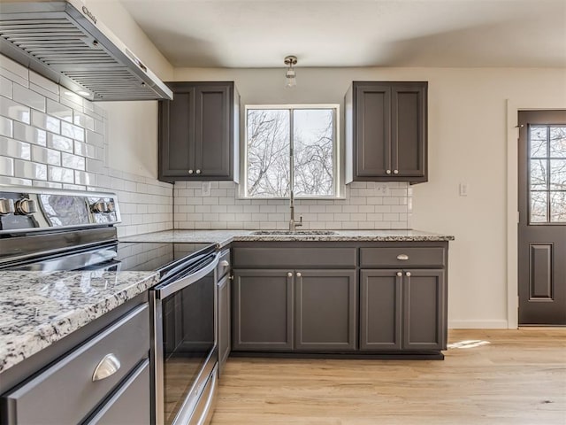 kitchen with electric range, light wood-style floors, extractor fan, and a sink