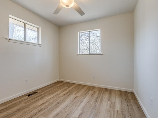 empty room featuring visible vents, baseboards, wood finished floors, and a ceiling fan