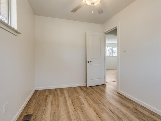 unfurnished room with visible vents, baseboards, light wood-type flooring, and a ceiling fan