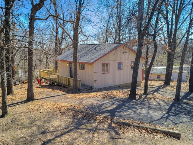 view of side of home featuring crawl space, a wooden deck, and a shingled roof