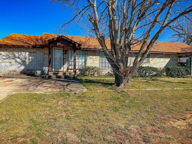 single story home featuring brick siding and a front yard