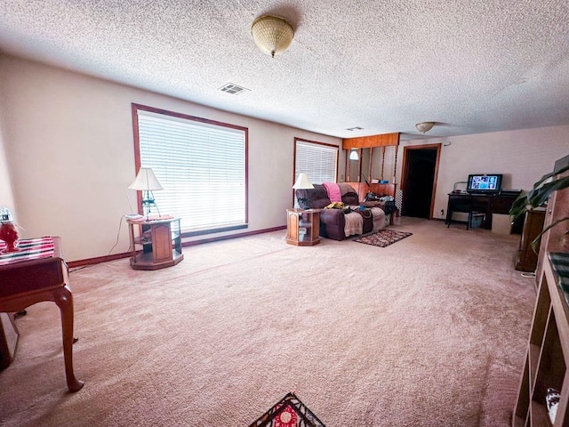 living area with visible vents, carpet flooring, and baseboards