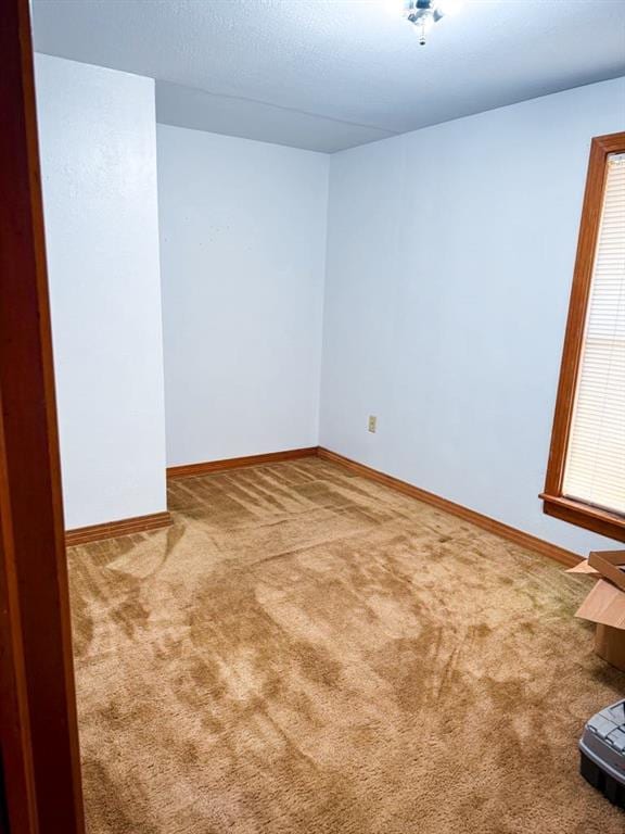 unfurnished room featuring baseboards and carpet floors