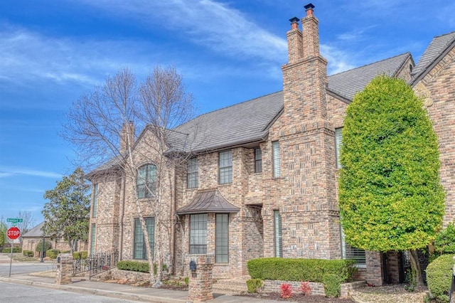 tudor-style house with brick siding and a chimney