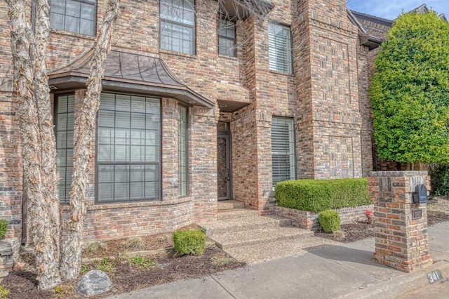 doorway to property with brick siding