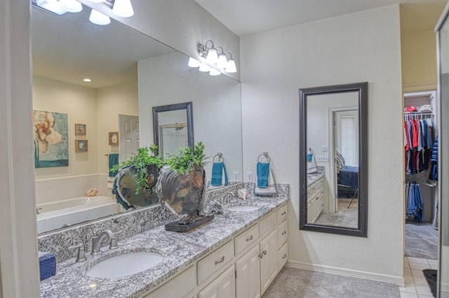 bathroom featuring a sink, a walk in closet, double vanity, and tile patterned floors